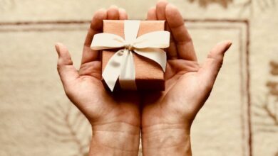 Gifts - Close-up of hands holding a beautifully wrapped gift box with a ribbon, perfect for celebrations and surprises.