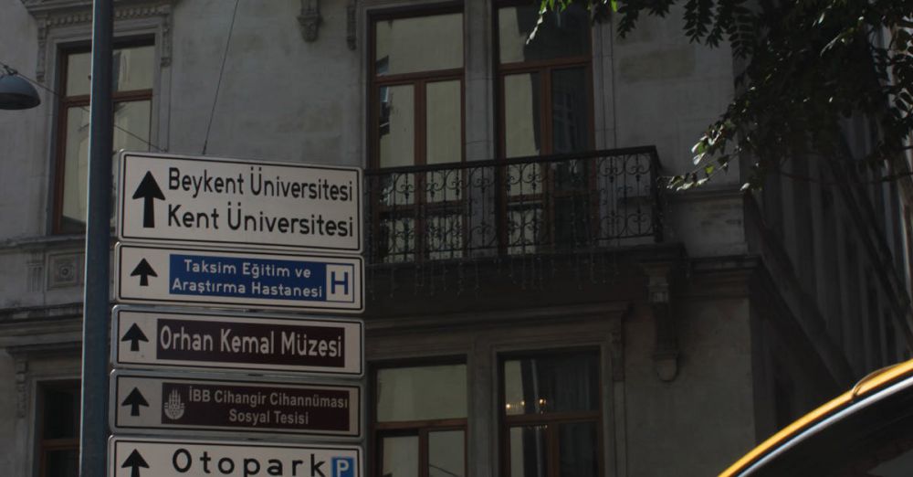 Educational Museums - Street scene in Istanbul with signs pointing to Baykent University and Orhan Kemal Museum.