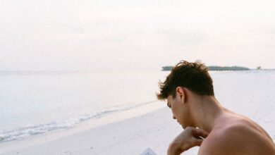 Books - A man enjoys reading a book on a serene Maldives beach, capturing the essence of relaxation.