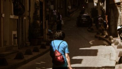 Architecture Museums - A woman walks through a sunlit alley in Istanbul, Türkiye, showcasing urban life.