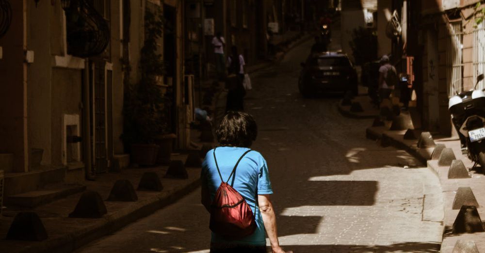 Architecture Museums - A woman walks through a sunlit alley in Istanbul, Türkiye, showcasing urban life.