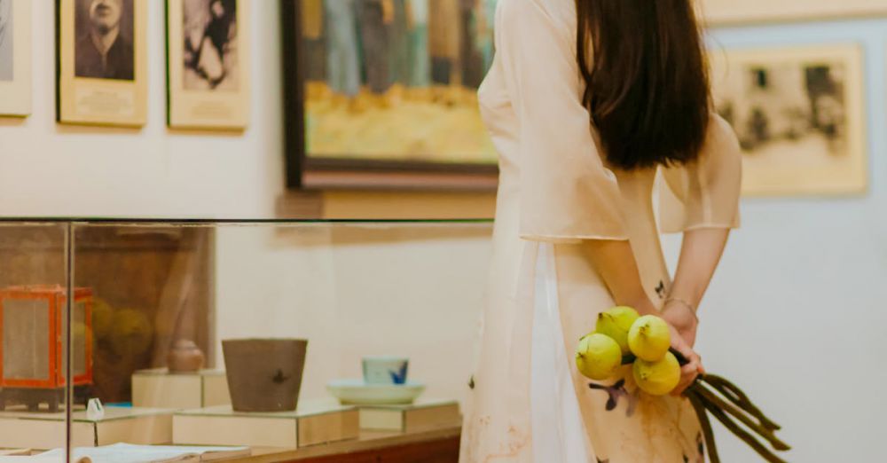 Historical Exhibits - A woman in traditional attire examines exhibits and paintings in a museum.