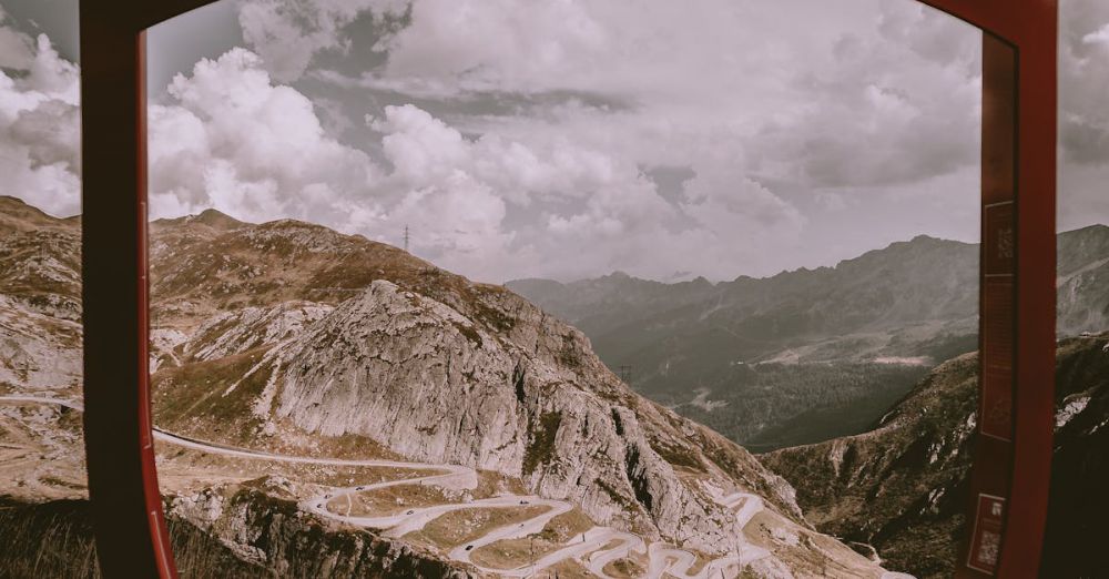 Scenic Routes - Discover the stunning Tremola Pass on the Grand Tour of Switzerland captured through an iconic red frame.