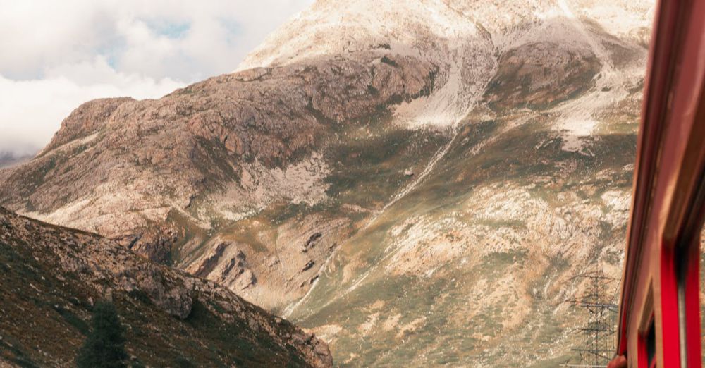 Rocky Road Trips - Red train winds through the picturesque mountains of Zermatt, Switzerland, capturing stunning alpine views.