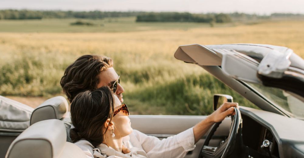 Weekend Road Trips - A couple enjoys a romantic drive through scenic fields in a stylish convertible.