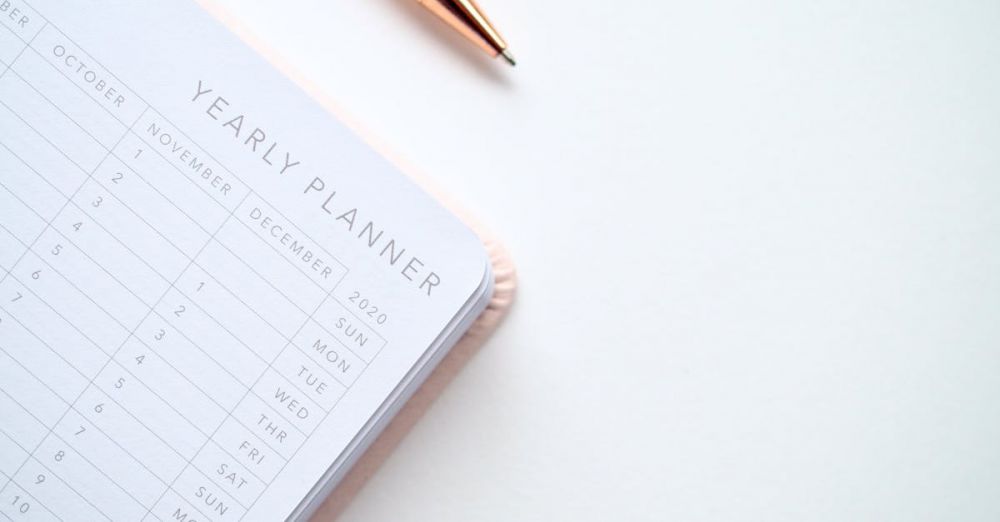 Planner - A stylish yearly planner open to a 2020 calendar page, accompanied by a golden pen on a clean white surface.