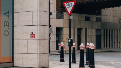 Road Trip Safety - Vintage urban street view featuring 'Give Way' sign in central London.