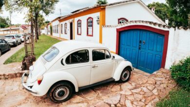 Scenic Drives - A classic white car parked in a charming street in Tiradentes, Brasil showcasing historic architecture.