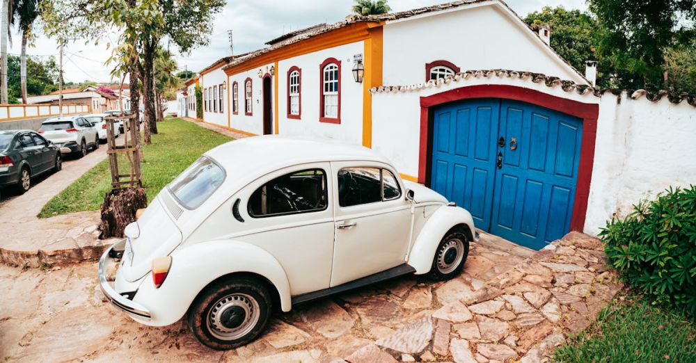 Scenic Drives - A classic white car parked in a charming street in Tiradentes, Brasil showcasing historic architecture.