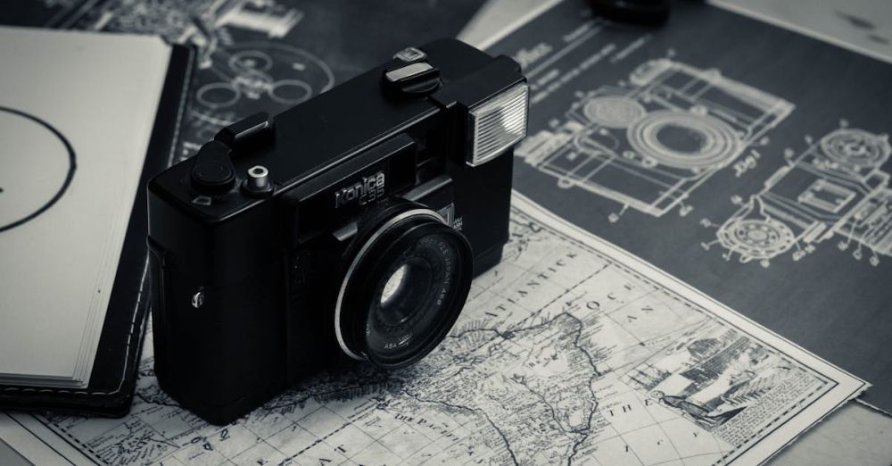 Photography Tour Planning - From above of black and white vintage film camera laced on table with map and notebook