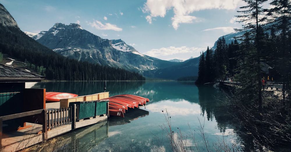 BC Photography - Beautiful view of canoes on a tranquil lake surrounded by mountains in British Columbia, Canada.