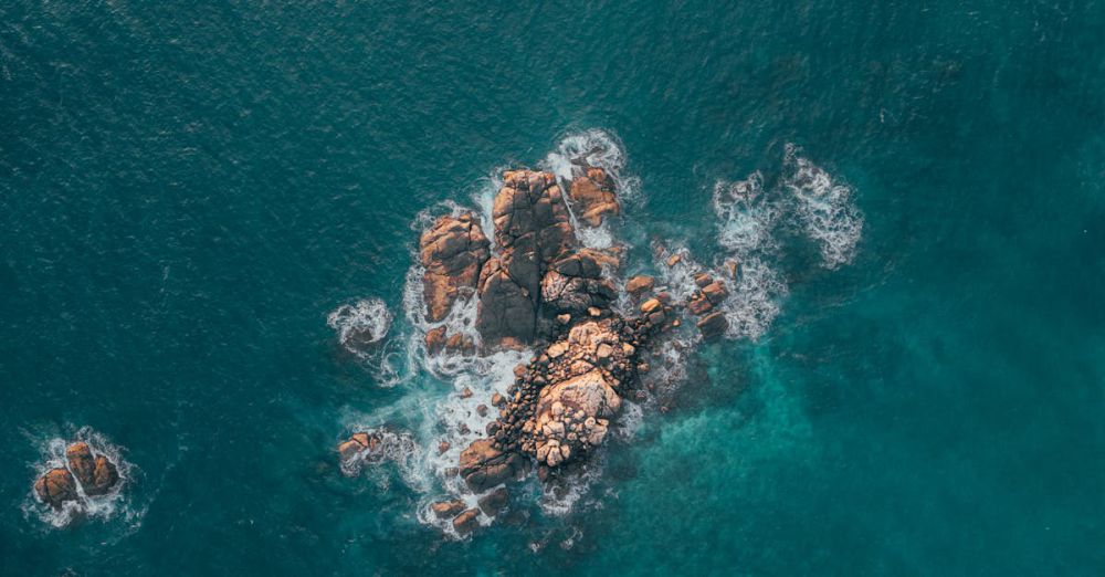 Rocky Photography - Stunning aerial shot of a rocky island surrounded by blue ocean waves in Sri Lanka.