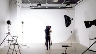 Photography Skills - Back view of unrecognizable professional photographer taking photo of anonymous model in modern light studio