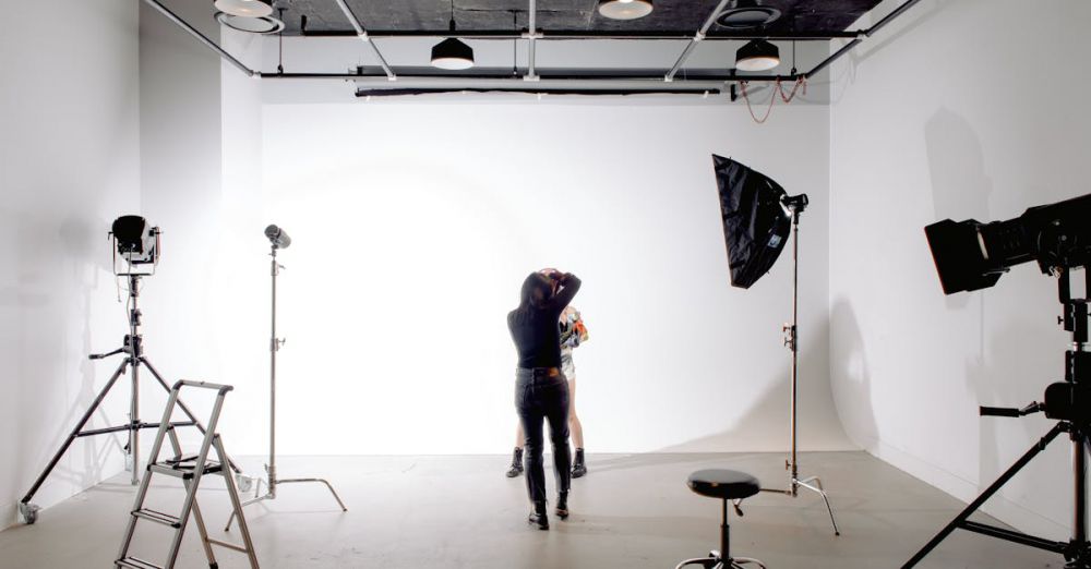 Photography Skills - Back view of unrecognizable professional photographer taking photo of anonymous model in modern light studio