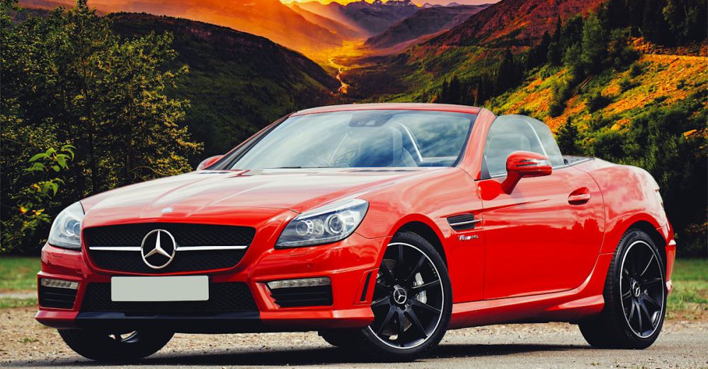 Tour Style - Stunning red Mercedes Benz convertible parked against a breathtaking Scottish sunset backdrop.