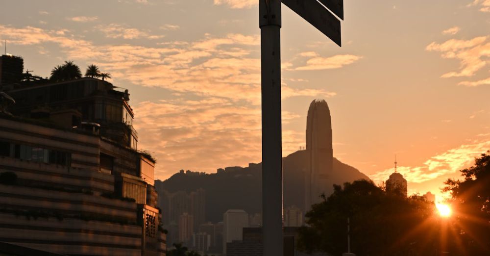 Popular Photography - Captivating sunset over Hong Kong skyline with a prominent street sign in the foreground.