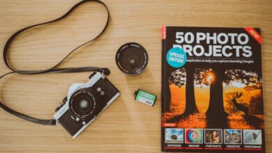 Photography Guide - Vintage film camera with photography project book and accessories on wooden background.