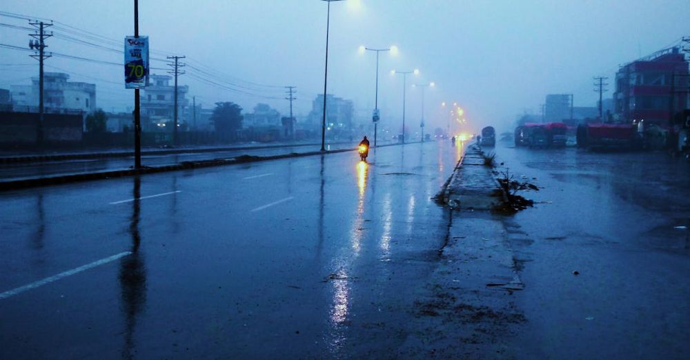 Landscape Photography Tips - Rain-soaked street at twilight with glowing streetlights and misty atmosphere.