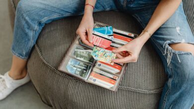 Gift Cards - Female sitting casually organizing various colorful cards in a wallet.