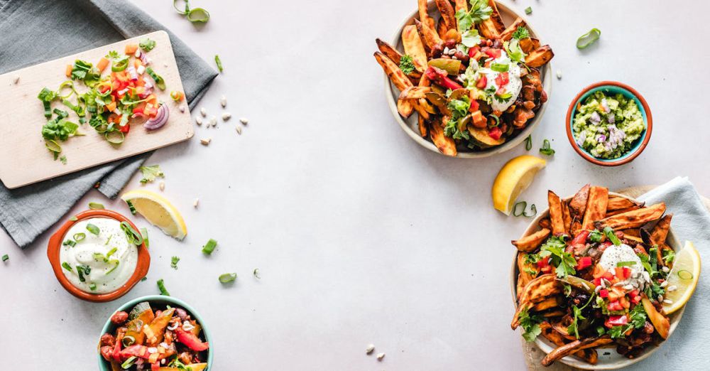 Food Photography - Colorful flat lay featuring sweet potato fries, guacamole, and fresh veggies, perfect for a healthy meal.