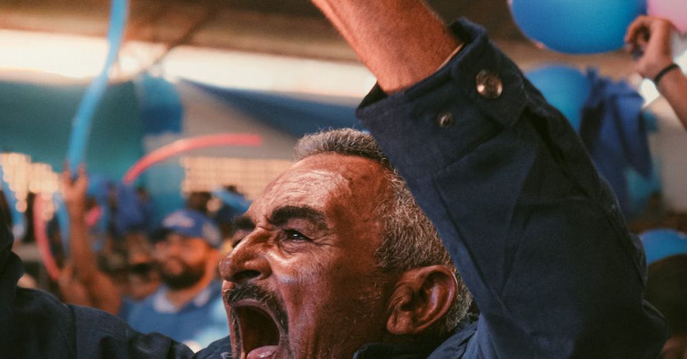 Outdoor Festivals - Senior man passionately cheering at a colorful festival in Brazil, surrounded by balloons.