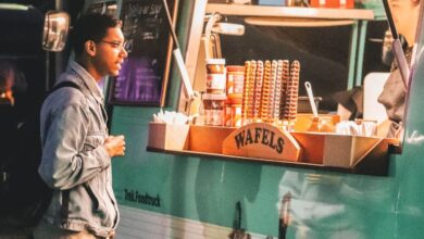 Food Trucks - A customer waits at a vibrant waffle food truck in Weert, Netherlands at night.