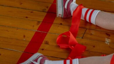 Popular Zip Lining - Close-up of legs in sneakers and ribbons on a gym floor, showcasing casual style.