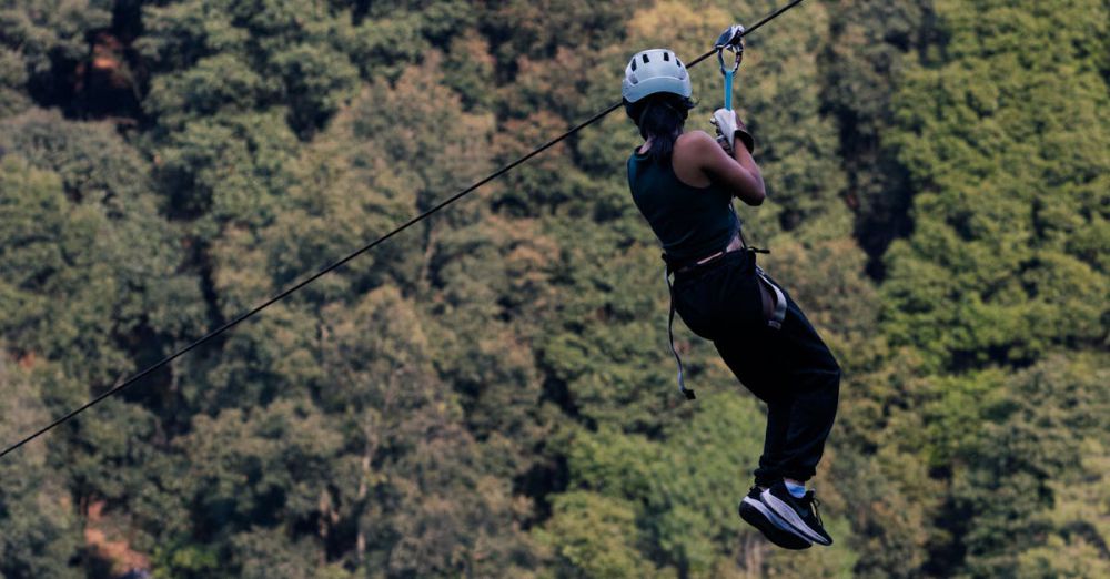 Mountain Zip Lining - An adult man ziplining through the dense forest of Villa del Carbón in daylight.