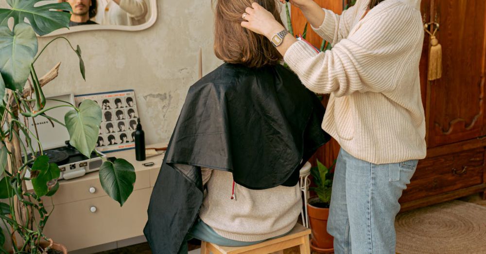 Experiences - A hairdresser styles a client's hair in a cozy, indoor salon setting, reflected in a wall mirror.