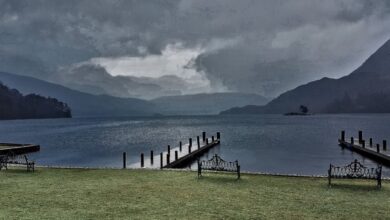 Fishing Spots - Peaceful lakeside view in Cumbria, UK, featuring benches and docks under a dramatic sky.