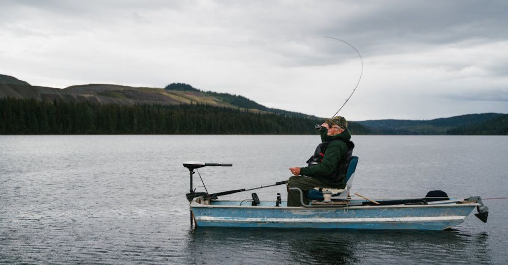 BC Fishing - An old man fishing peacefully on a lake in BC, Canada, amidst beautiful nature.