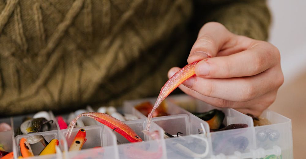 Trout Fishing - Hand selecting vibrant fishing lure from plastic container. Perfect for angling enthusiasts.