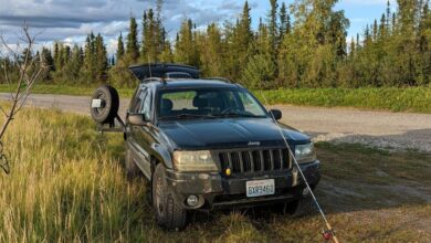 Northern Pike Fishing - Black Jeep parked in grassy area of Alaska with a fishing rod.