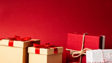 Gifts - A collection of colorful gift boxes with ribbons on a rich red background, perfect for holiday themes.