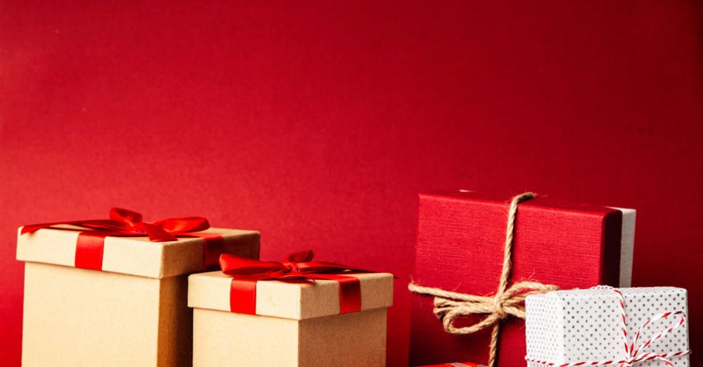 Gifts - A collection of colorful gift boxes with ribbons on a rich red background, perfect for holiday themes.