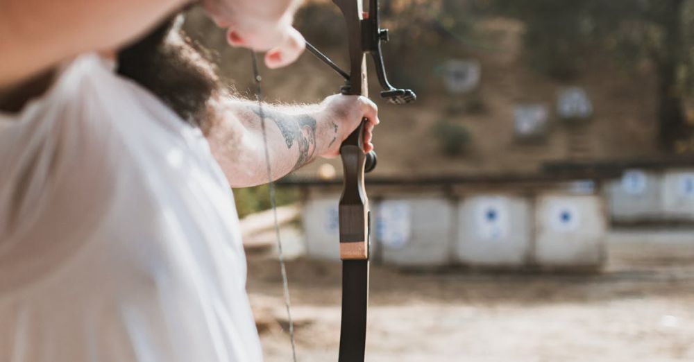 Elk Hunting - Adult practicing archery at outdoor range with traditional bow.