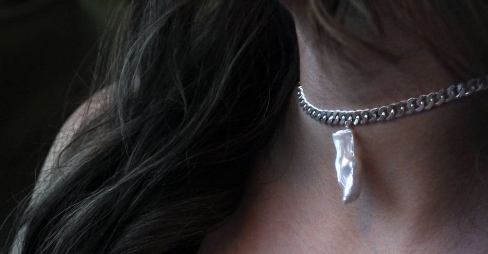 Jewelry - Close-up of a silver pendant necklace worn by a woman, showcasing fine jewelry and fashion.