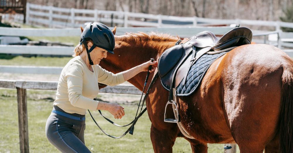 Horseback Riding Preparation - A woman preparing to mount her horse using steps in a sunny outdoor setting.