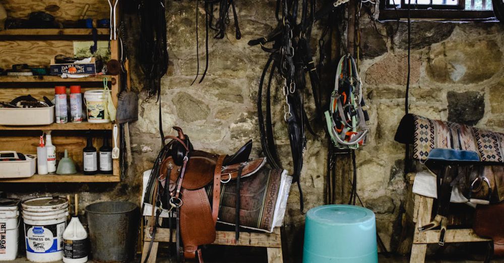 Ontario Horseback Riding - A cozy stable with equestrian equipment, including saddles and pails, against a stone wall.