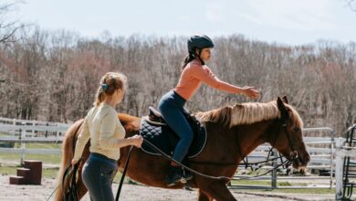 Horseback Riding Instructor - Two women engaged in a horseback riding lesson in an outdoor setting.