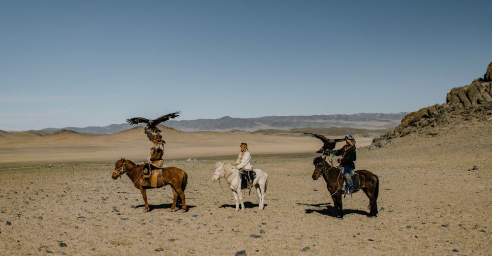 Rockies Horseback Riding - Traditional Mongolian eagle hunters on horseback in the vast desert landscape.