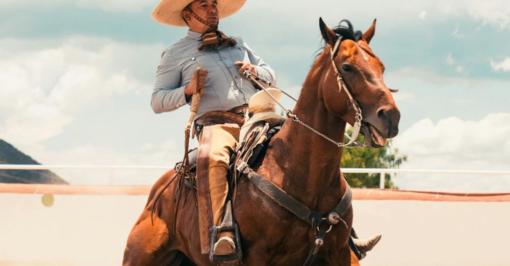 Cultural Horseback Riding - Dynamic shot of a Mexican charro skillfully riding a horse, stirring up dust in Pachuca, Mexico.