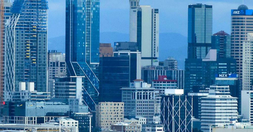 Tallest Waterfalls - Panoramic view of Auckland city skyline, highlighting the iconic Sky Tower against a cloudy sky.