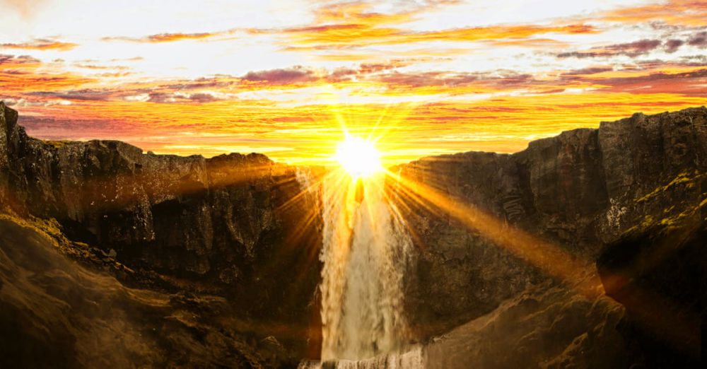 Photography Waterfalls - A stunning sunset casting vibrant colors over a powerful waterfall surrounded by cliffs.