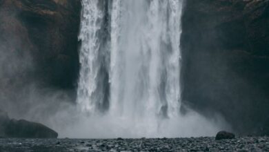 Rockies Waterfalls - Stunning view of Skógafoss waterfall cascading in a dramatic, misty Icelandic landscape.