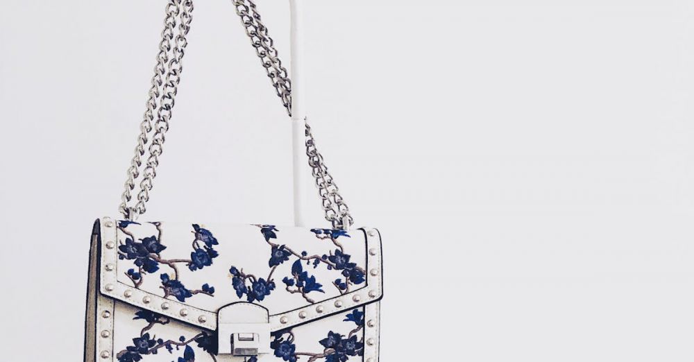 Handbag - Elegant white handbag with blue floral design and silver chain, perfect for fashion enthusiasts.