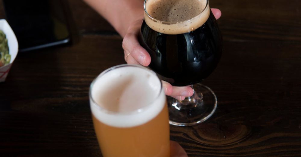 Beer Enthusiasts - Two people toasting with craft beers in a welcoming bar atmosphere.