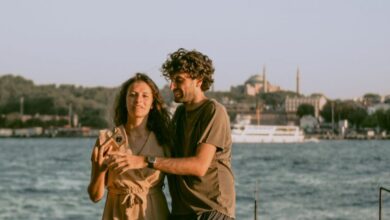 Couple Tours - A couple enjoying a leisurely walk by the Bosphorus with iconic Istanbul architecture in the background.