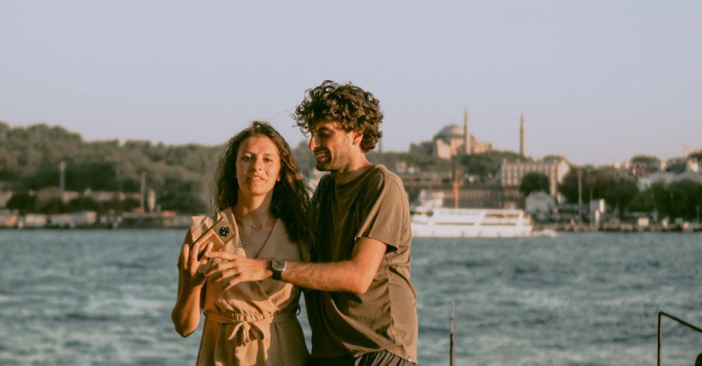 Couple Tours - A couple enjoying a leisurely walk by the Bosphorus with iconic Istanbul architecture in the background.