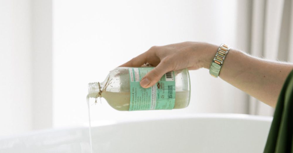 Skincare - A woman pouring aromatherapy bath oil into a bathtub for a relaxing skincare routine.